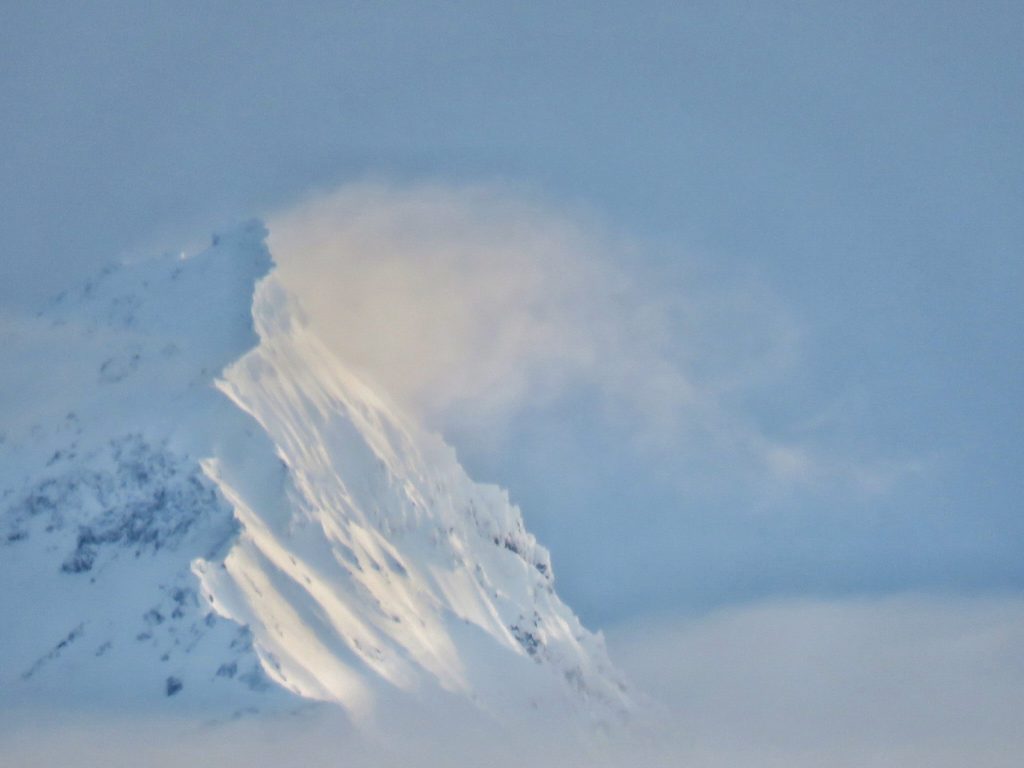 Wind blowing snow from mountain peak